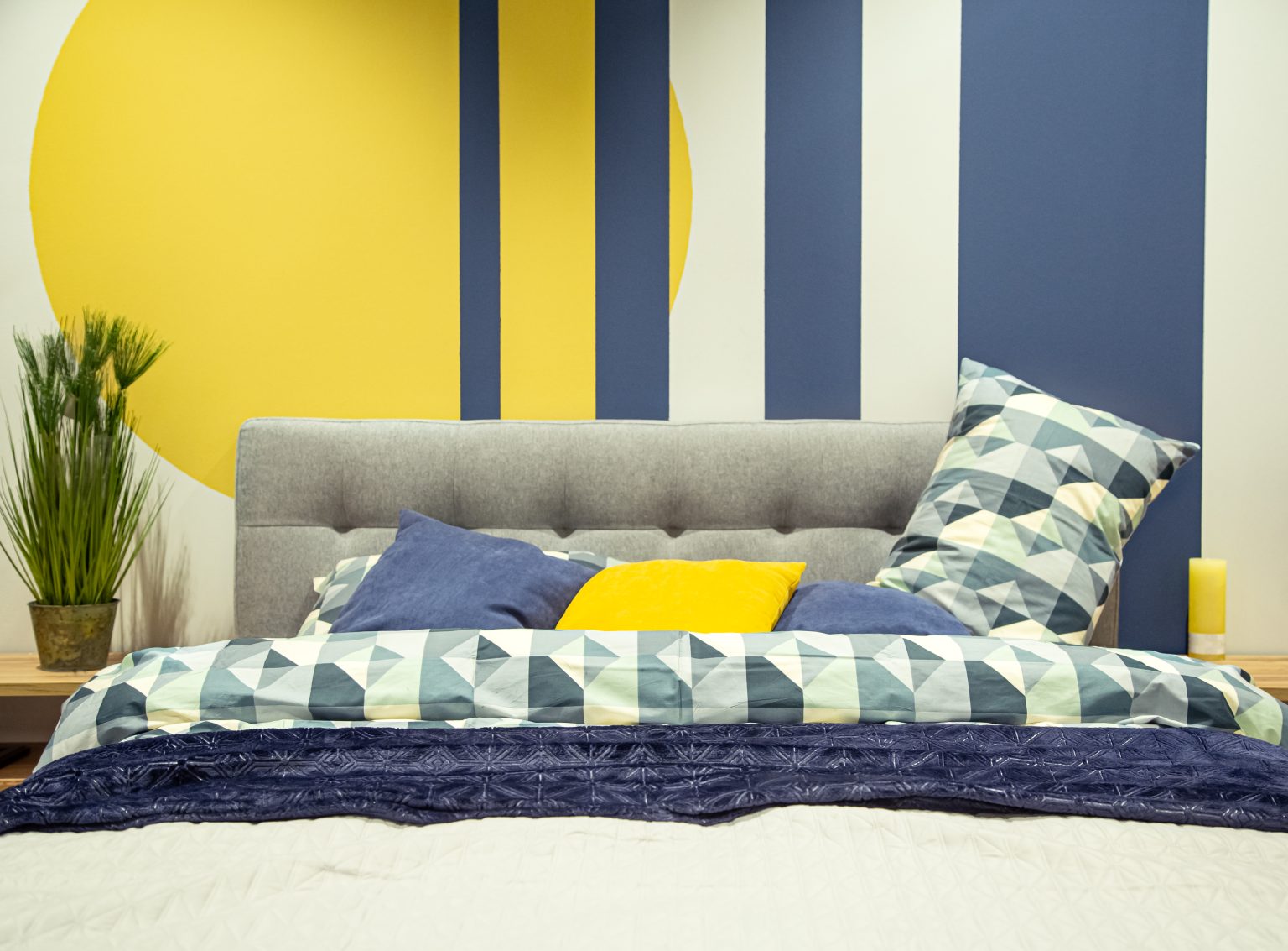 Modern bedroom interior in blue and yellow tones.